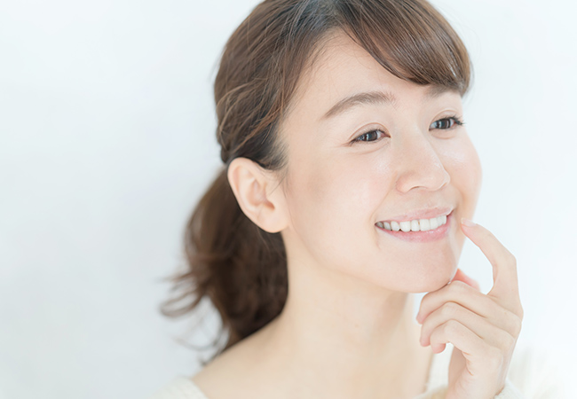 歯を見せてほほ笑む女性